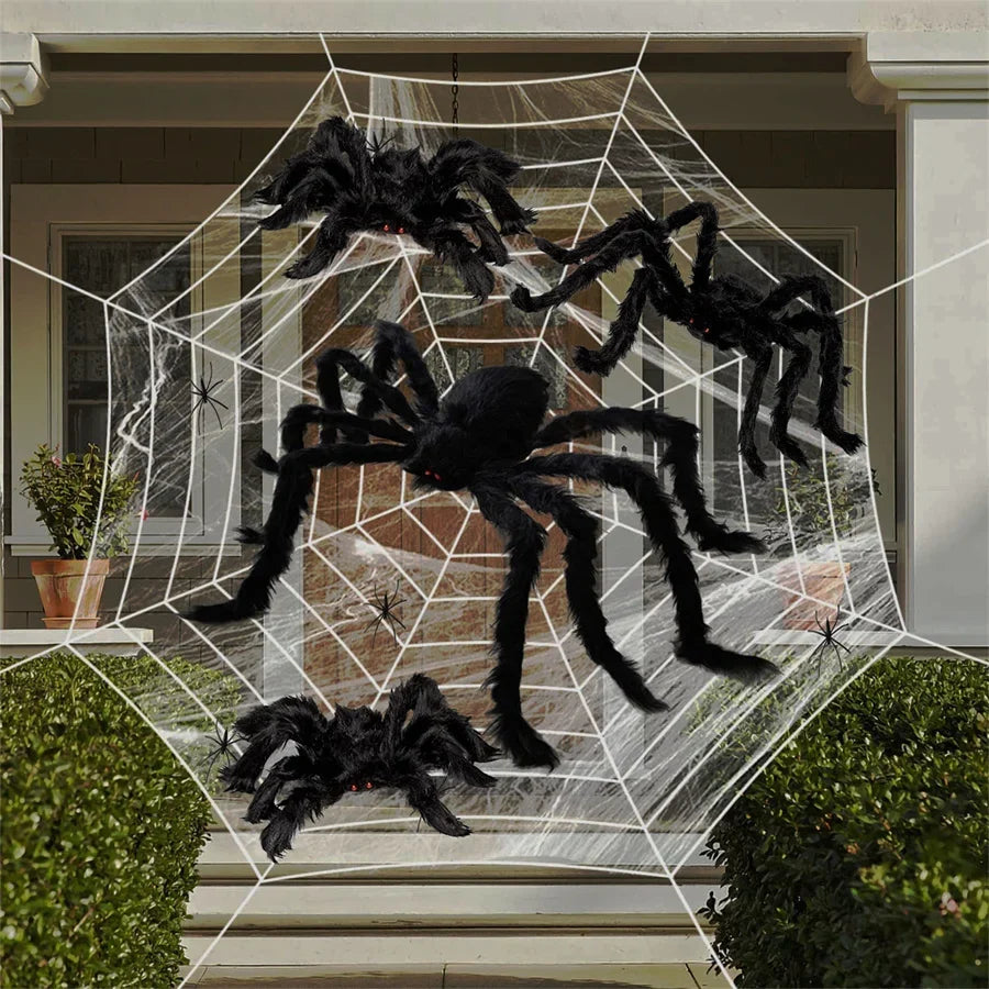 Araignée géante sur sa toile devant une maison décorée pour Halloween