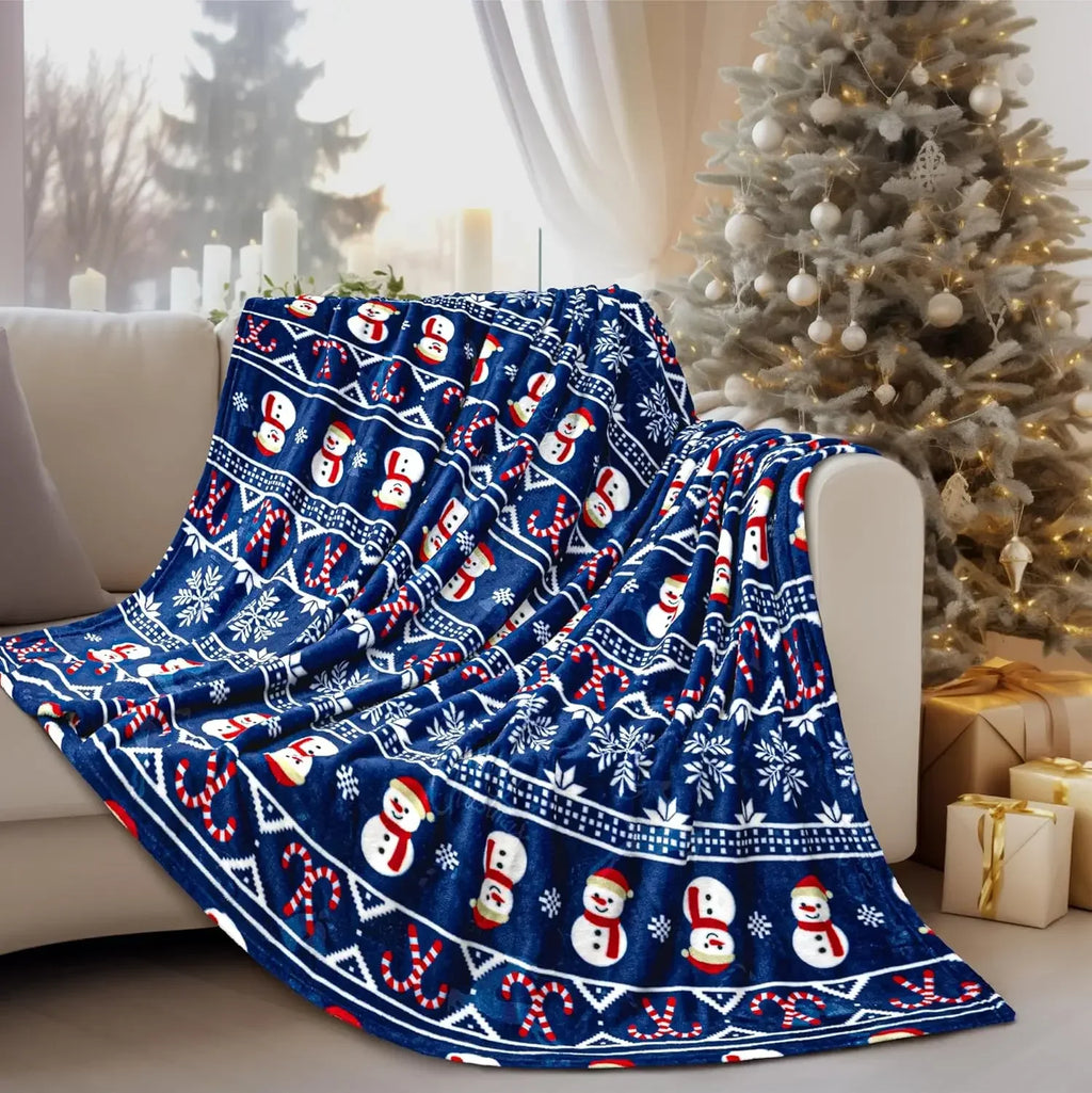 Plaid de Noël bleu à bonshommes de neige sur un canapé près du sapin