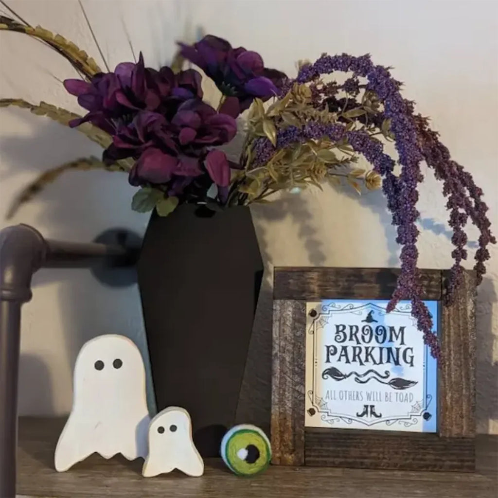 Vase cercueil garni de fleurs violettes dans un décor d'Halloween