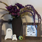 Vase cercueil garni de fleurs violettes dans un décor d'Halloween