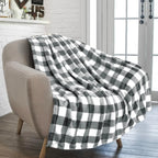 Plaid à carreaux gris et blanc posé sur un fauteuil
