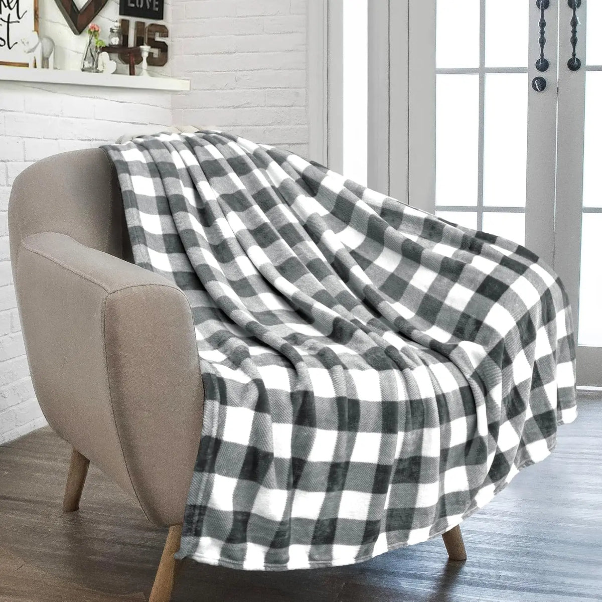 Plaid à carreaux gris et blanc posé sur un fauteuil