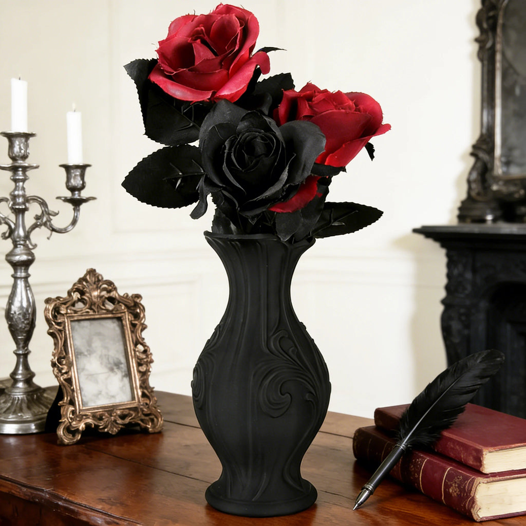 Le Vase Baroque Noir garni de roses rouges et noires sur une commode