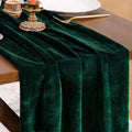 Chemin de table en velours vert émeraude drapé sur une table de fête